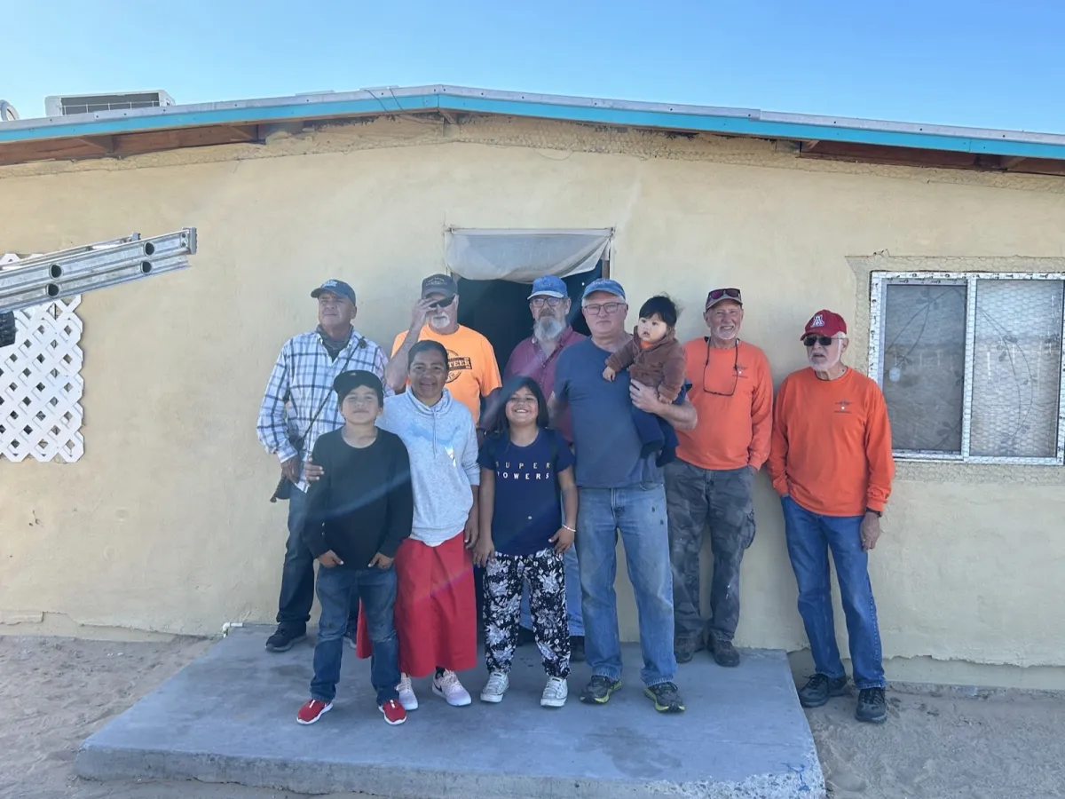 Old Brothers volunteers with a family at their home
